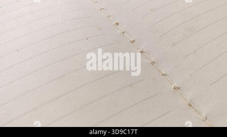 Close-up Macro View of Open Lined Journal Pages Showing Visible Spine Stitching and Hand-Crafted Bookbinding Detail Stock Photo