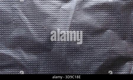 Abstract Crumpled Black Plastic or Fabric Texture with Repeating Grid Dot Pattern and Dramatic Shadow Details Stock Photo