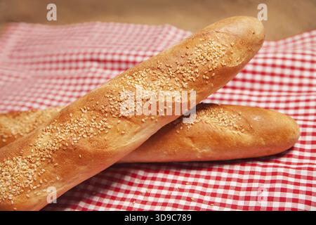 A pair of French bread isolated on checkered napkin Stock Photo
