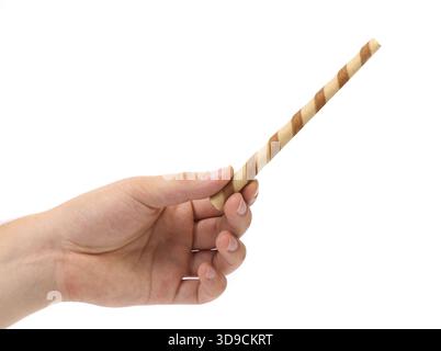 Hand holds striped wafer rolls filled with chocolate isolated on white Stock Photo