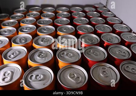 Rows of aluminum beverage cans for soda or drink on factory production line. This orderly pattern shows mass manufacturing, storage, and beverage indu Stock Photo