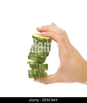 Hand holds stack of sliced cucumber. White background Stock Photo