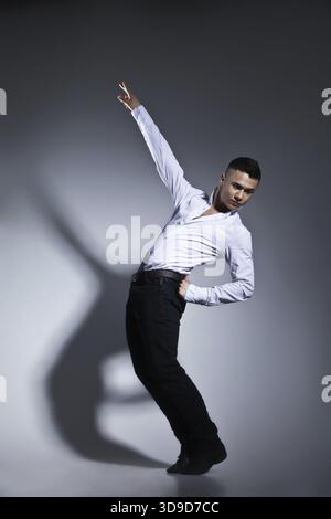 Modern style dancer posing on grey studio background Stock Photo