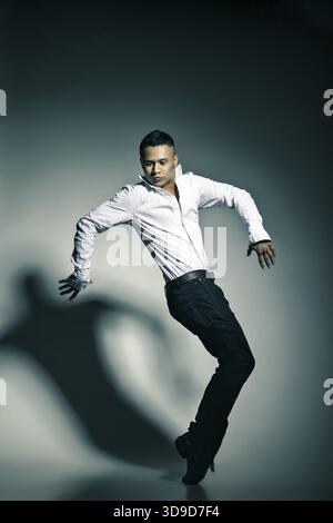 Modern style dancer posing on grey studio background Stock Photo