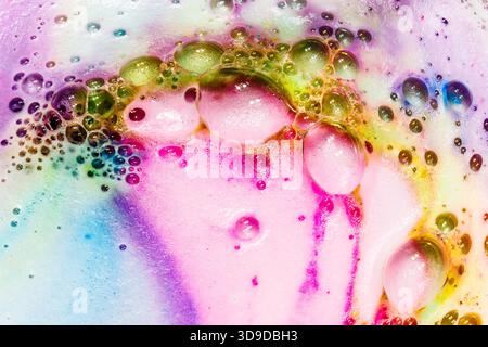 Swirling liquid colors and bubble formations blending into a crescent-like, dreamlike abstract pattern. Stock Photo