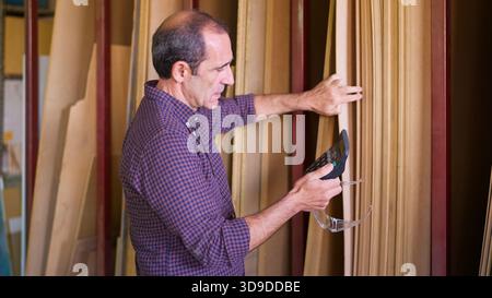 Warehouse worker counting wood stock in lumber warehouse Stock Photo