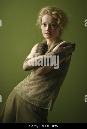Portrait of attractive lady in a green dress on a green background Stock Photo