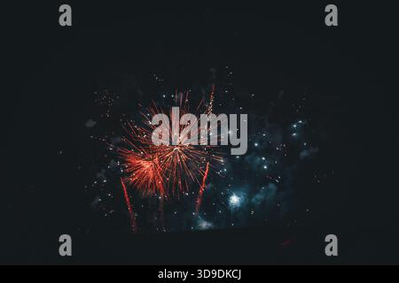 Red Fireworks Burst in the Night Sky on New Year’s Eve Stock Photo