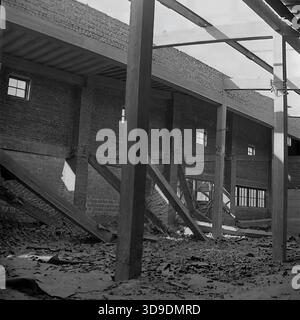 Sloviansk, Ukraine, USSR, 1960s. An archival interior view of a workshop under construction at the Armaturno-Izolyatorny Zavod (AIZ). The vast industrial hall features high steel truss ceilings with skylights and heavy vertical support beams. The floor is scattered with construction debris and raw materials. This atmospheric image captures the expansion of industrial capacity and the scale of engineering works in the peaceful Donbas region during the Soviet era. Stock Photo