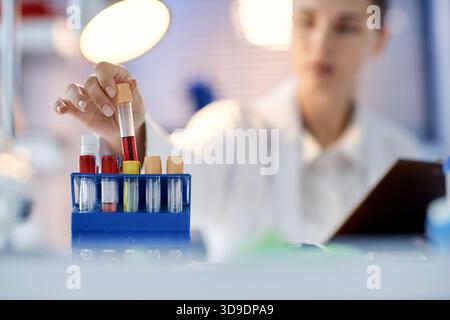 Young Caucasian Woman Scientist Examining Blood Samples in Laboratory Setting Stock Photo