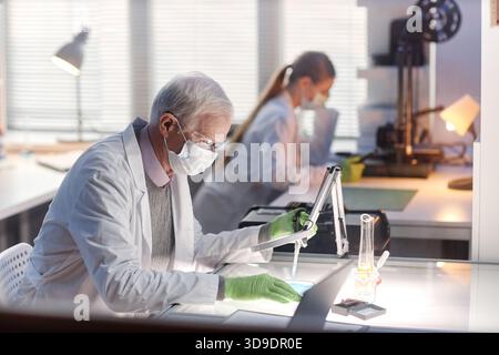 Senior Caucasian Man Conducting Scientific Experiment in Modern Laboratory Stock Photo