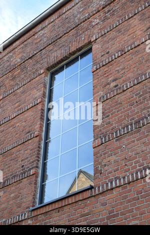 modern window in an old red brick building Stock Photo