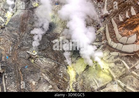 A fumarole field with sulphur-yellow deposits in the Owakudani Crater, Hakone, Kanagawa, Japan. Steam rises in dense plumes from active vents; the triangular concrete blocks of the erosion-control terraces are visible on the right-hand side of the image. One of the monitoring stations can be seen on the left-hand side of the picture Stock Photo