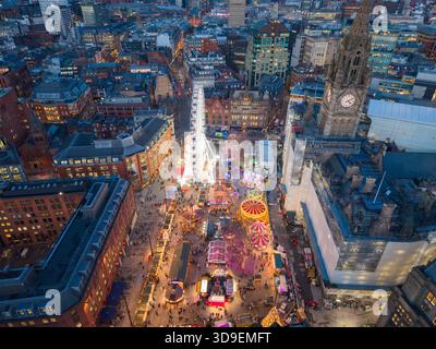 Aerial view of Manchester’s Albert Square with the Christmas markets, bright festive wheel and Town Hall tower at dusk. Stock Photo