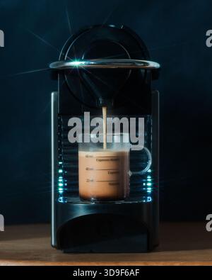 coffee machine pouring an espresso coffee in a coffee glass Stock Photo