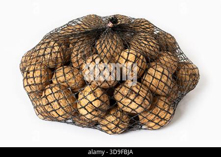 Walnuts in a black mesh bag packaging isolated on white background Stock Photo