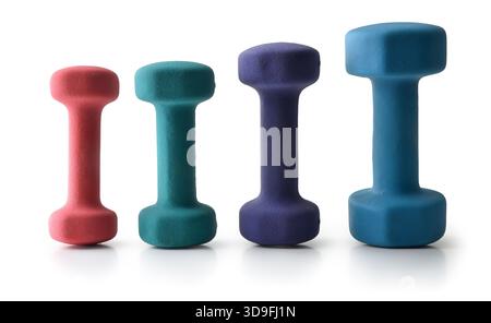 Collection of neoprene dumbbells of different weights and colors in a row reflected on a white table and isolated white background. Stock Photo