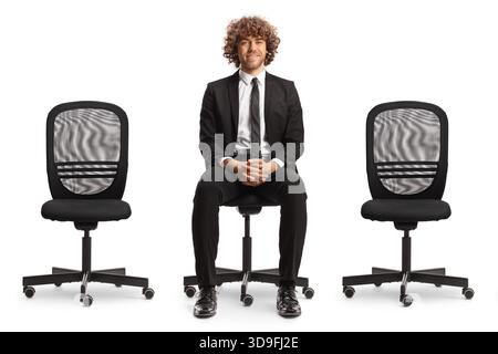 Young professional man sitting between empty office chairs isolated on white background Stock Photo