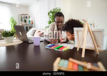 Mother and child drawing together while working from home Stock Photo