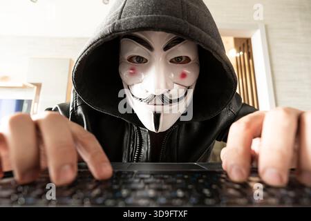 Hacker sitting behind computer. Anonymous Hacking computer networks. June 1, 2022. Barnaul. Russia. Stock Photo