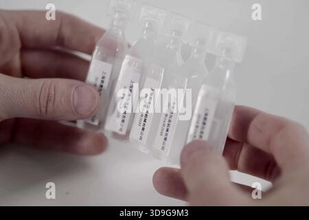 Krasnodar, Russia - May 29, 2018: Plastic ampoules with a medicinal substance from China in the hands of a man. Stock Photo