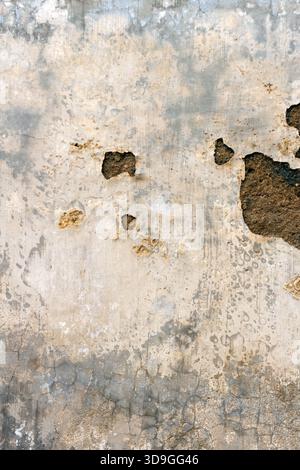 A soft, vertical texture of light beige and grey weathered concrete with subtle surface damage, pitting, and small, dark exposed holes. A less aggress Stock Photo
