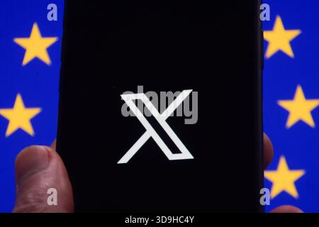 London, UK. 5th December 2025. The X logo is displayed on a phone with a European Union flag in the background. Elon Musk’s social media platform X, formerly Twitter, has been fined 120 million euros following a breach of new EU digital laws, including 'deceptive' blue tick verification, lack of transparency in advertising on the platform, and failure to provide access to public data. Credit: Vuk Valcic/17�Թ����� Stock Photo