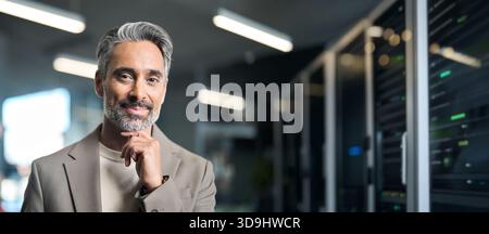 Happy mature man on data center server room background. Banner Stock Photo