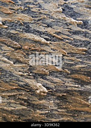 Detailed close up of natural rock texture background. This abstract pattern in brown and grey stone shows geological layers and rough, rugged surface, Stock Photo