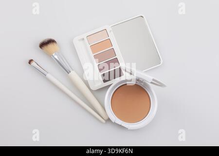 Makeup and beauty cosmetics products, opened compact powder and eyeshadow palette with a soft brushes. Isolated on white surface. Advertising for stor Stock Photo