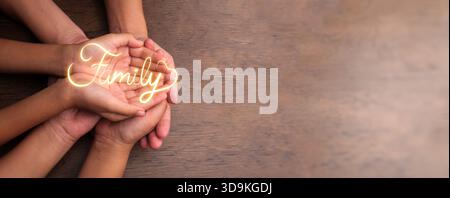 Hands of father, mother, and daughter holding each other with a glowing Family word. Love, unity, trust, emotional bond and support, nurturing relatio Stock Photo
