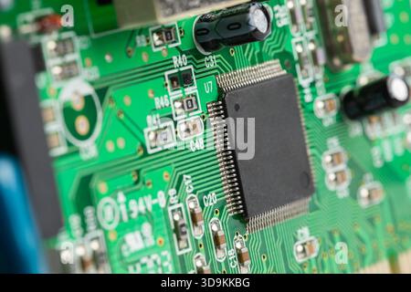Close-up view of a square silicon chip on a green printed circuit board. the chip has copy space. Stock Photo