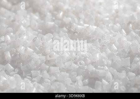 White, translucent plastic pellets, raw industrial material for manufacturing, molding, and extrusion processes. Stock Photo
