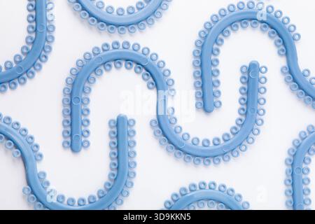 Close-up of blue orthodontic elastic ligatures. These small rubber bands secure the archwire in braces, aiding teeth alignment and orthodontic... Stock Photo