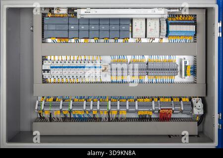 Colorful wires connect to a professional electrical terminal box with switches, fuses, and connectors for various electrical elements. Stock Photo
