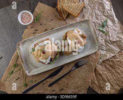 Top view of eggs benedict with poached eggs, ham, and hollandaise sauce Stock Photo