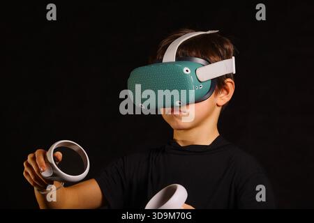 Boy immersed in VR experience, gazing upward with concentrated expression, virtual reality technology concept. Stock Photo