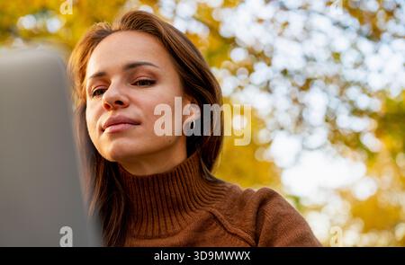 Closeup portrait of modern woman working on laptop outdoors. Stock Photo