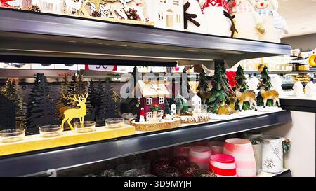 ISERLOHN, GERMANY — DECEMBER 06 2025: christmas reindeer and small decorative holiday houses displayed on shelf in woolworth store Stock Photo
