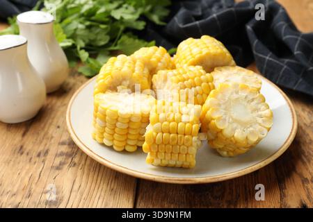 Pieces of boiled corn cobs on wooden table, closeup Stock Photo
