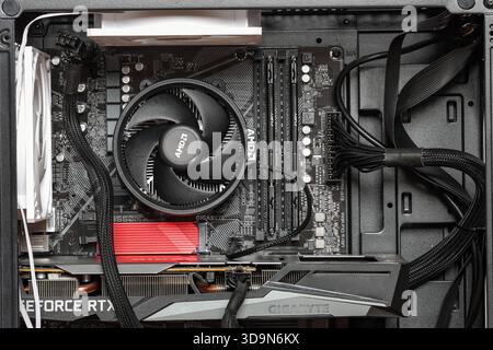 BANGKOK, THAILAND, 2025, An open-side view of a gaming desktop reveals a cooling fan, graphics card, motherboard, RAM, and neatly organized cables ins Stock Photo