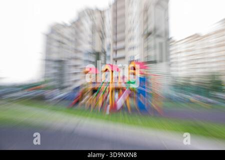 Playground in front of a residential building, captured with zoom blur technique, creating dynamic, radial motion effect. Stock Photo