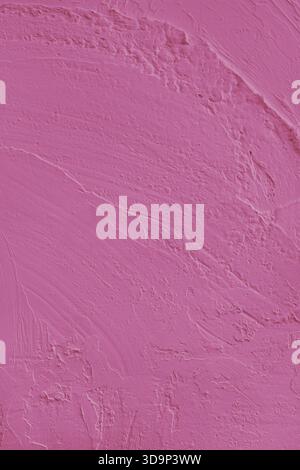 Close up, macro of vibrant pink colored cement wall surface with rough, heavily textured, and abstract plaster strokes. Grunge background, industrial Stock Photo