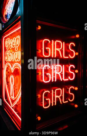 Red neon signs advertising 'Girls Girls Girls' and 'Peep Show', Soho, Westminster, London, England, UK Stock Photo