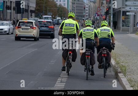 20 August 2025, Berlin: 23.11.2025, Berlin. Three police officers wearing high-visibility vests with the word "Polizei" on them ride on bicycles on a cycle path next to a street in Mitte. Photo: Wolfram Steinberg/dpa Photo: Wolfram Steinberg/dpa Stock Photo