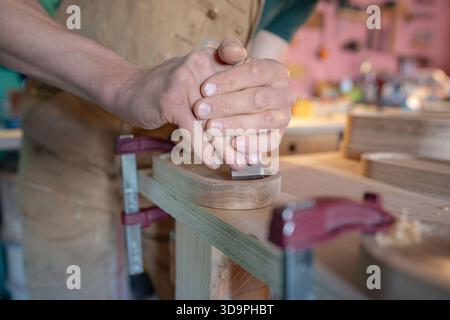 Carpenter small business owner working on stand for glasses of water in own carpentry workshop. Stock Photo