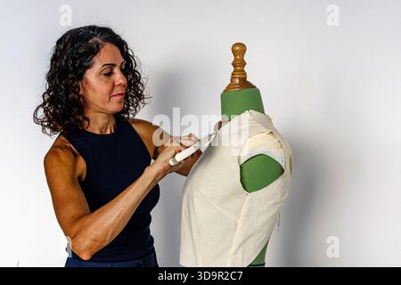 Woman fashion designer creating garment pattern on mannequin Stock Photo