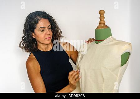 Woman fashion designer working on a dress pattern on mannequin Stock Photo