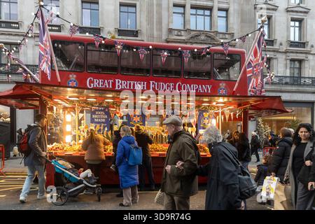 London, UK, 6 December 2025, A street stall of "Great British Fudge Company" set up in the shape of a red double-decker bus, decorated with Union Jack Stock Photo