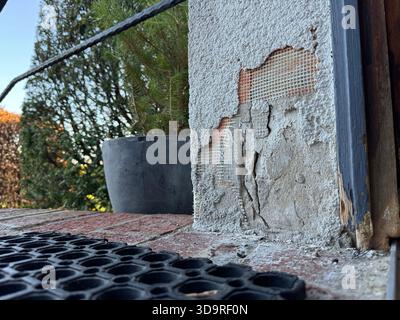 The outer layer of an insulation of a house thermal insulation composite system is damaged and the components are crumbled on the floor, in the backgr Stock Photo